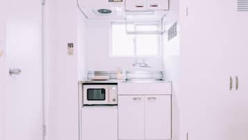 A white kitchen with a microwave, oven, and cabinets.