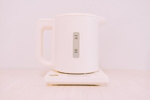A white electric kettle with a digital display on a white coaster. - Cozy Aesthetic 1BR Haven in Nakasu (Fukuoka)