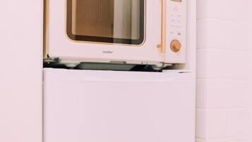 A compact kitchen with a built-in microwave and refrigerator.