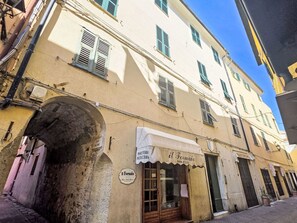 Eine enge Straße mit Gebäuden im traditionellen Baustil, darunter eine Bäckerei mit sichtbarem Schild.