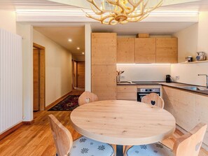 Una cocina moderna con armarios de madera, una mesa redonda de comedor y una araña.