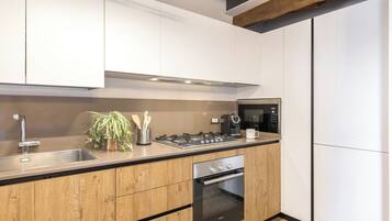 Een moderne keuken met houten kastjes, een ingebouwde gasfornuis, een magnetron en een oven.