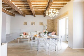 Una zona de menjador moderna amb sostre de fusta, un penjallum i una paret de maó.