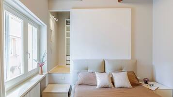 Ein Schlafzimmer mit Bett, Nachttisch und Fenster.