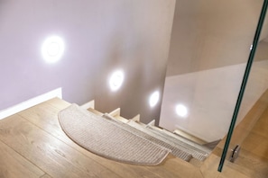 A wooden floor with a beige rug and a glass door.