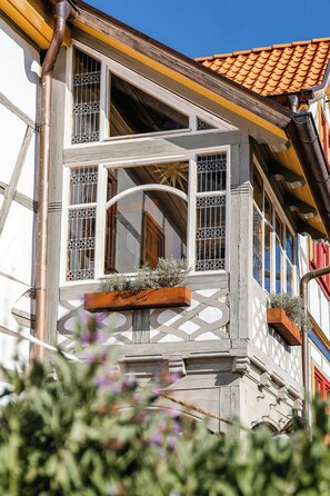 A building with a traditional architectural style, featuring a balcony with a wooden railing and flower boxes.