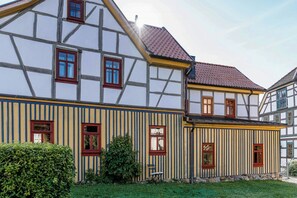 Ein traditionelles Fachwerkhäuschen mit vielen Fenstern und einem geneigten Dach.