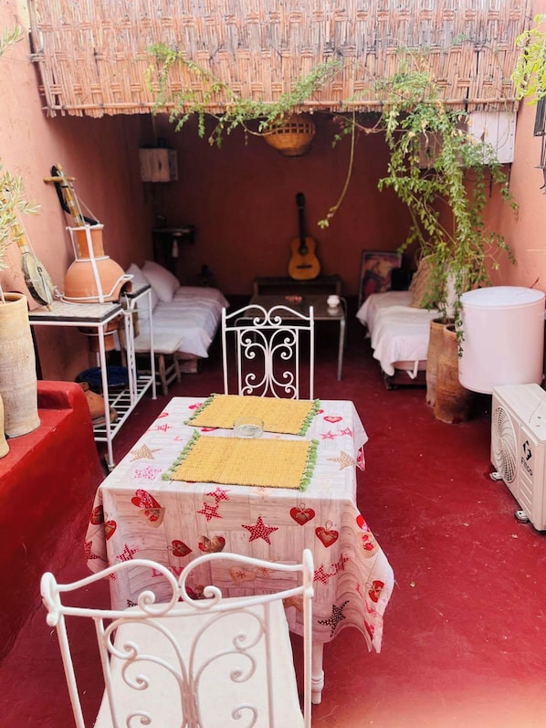 A cozy outdoor seating area with a table and chairs, a guitar, and a hammock. - hannah house marrakech (Marrakech)