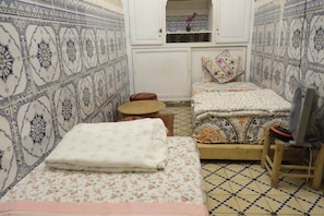 A small, compact room with two beds, a fan, and a small table. - hannah house marrakech (Marrakech)