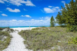 A beach path leading to a sandy beach with a clear sky. - Tortuga Inn Beach Resort #219 | Direct Gulf & Beach Views (Bradenton Beach)