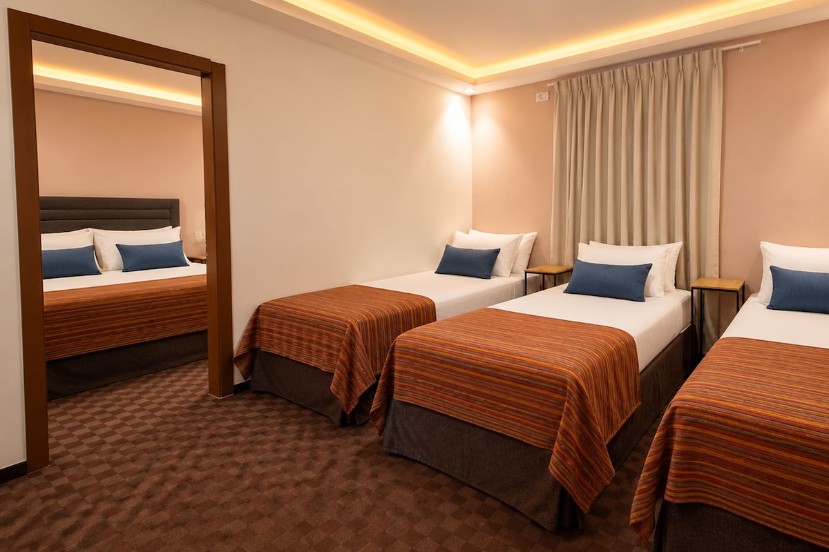 Habitación de hotel con tres camas individuales, un espejo grande, una ventana con cortinas y suelo alfombrado.