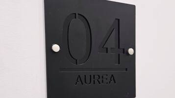 A black wall-mounted sign with the number '04' and the word 'AUREA' below it.