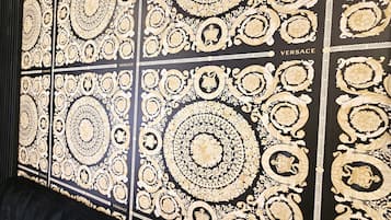 A wall with intricate gold patterns and the word 'VERSACE' repeated across it.