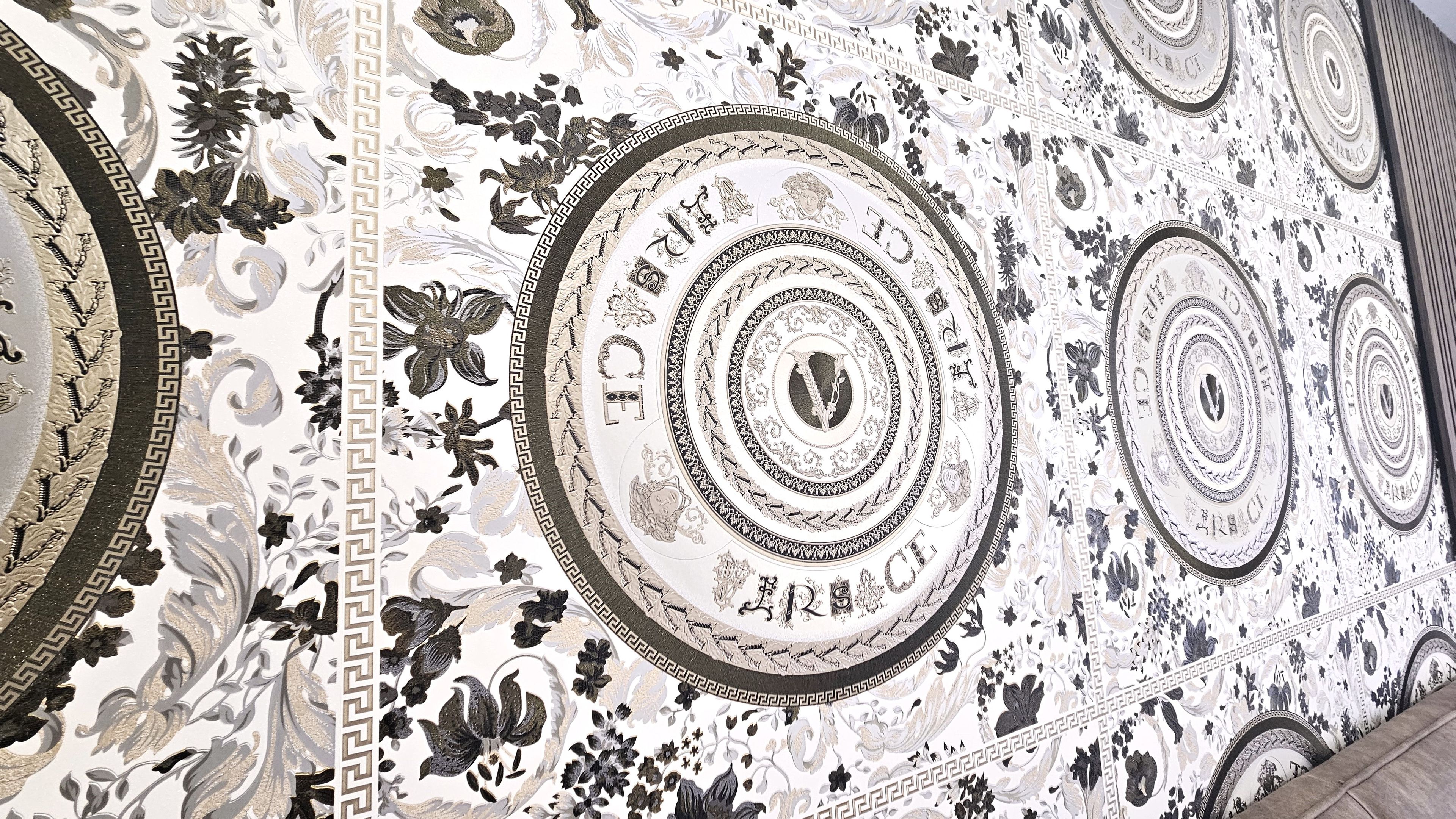 Un plafond richement décoré, orné de motifs complexes et de dessins circulaires.