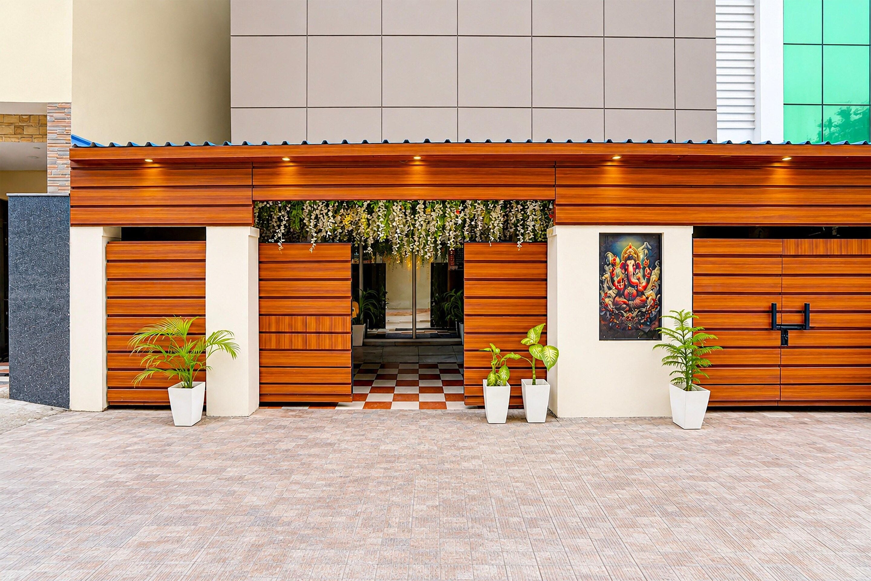 A modern building facade with a wooden panel design, a checkered floor pattern, and potted plants.