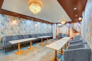 Ein moderner Loungebereich mit Sofas, Tischen, einer Chandelierleuchtre und einer Wand mit Muster.