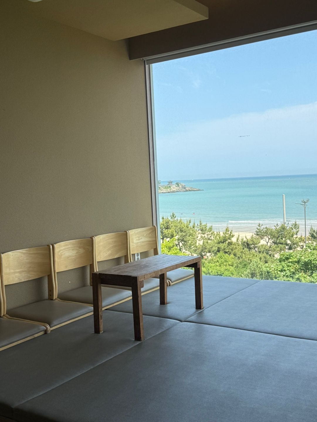 Une pièce avec un banc et une vue sur la mer.