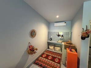 A compact kitchen with a sink, a small countertop, and a microwave.