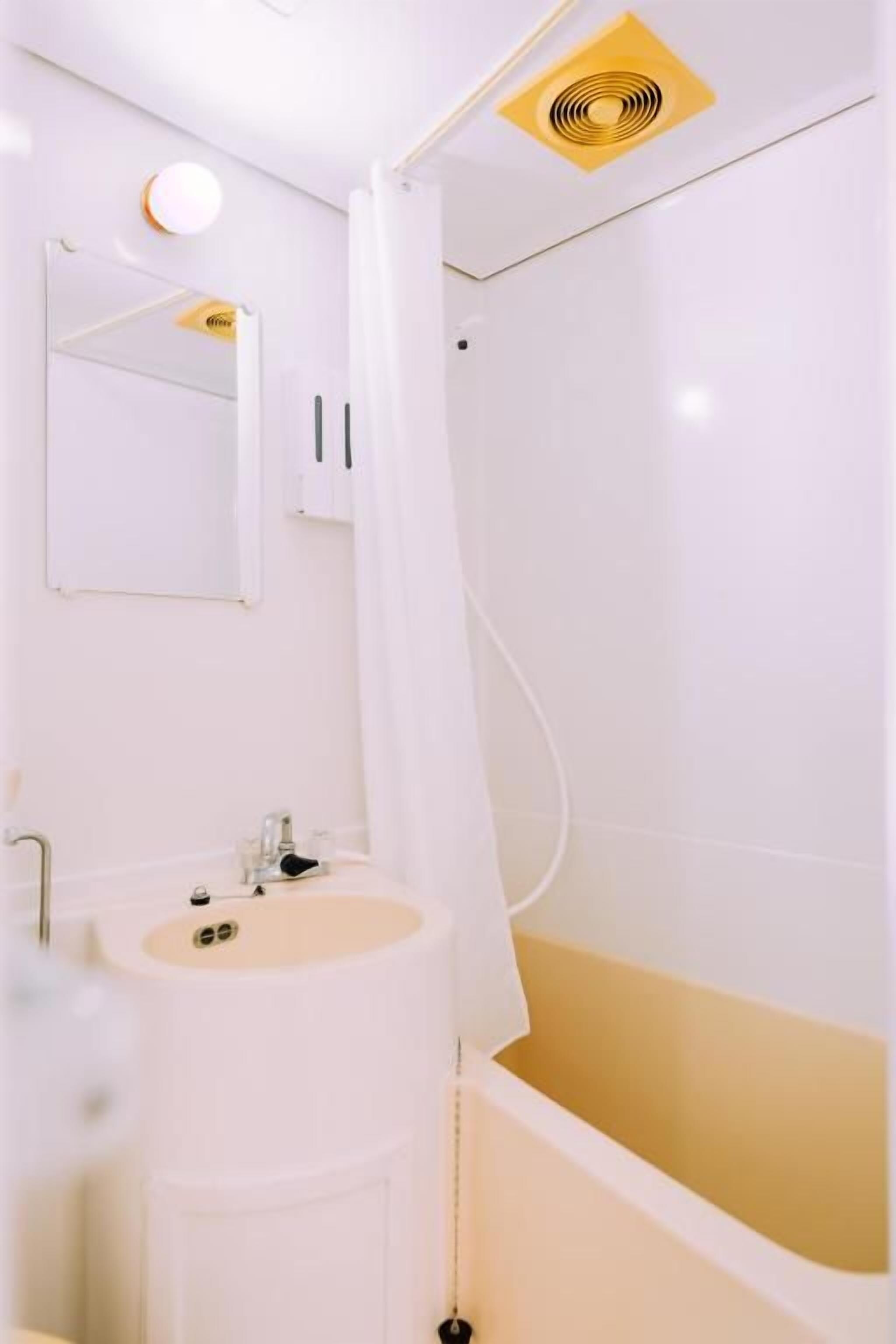 Un bany amb banyera, un lavabo i un mirall.