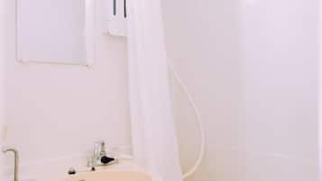 A bathroom with a bathtub, a sink, and a mirror.