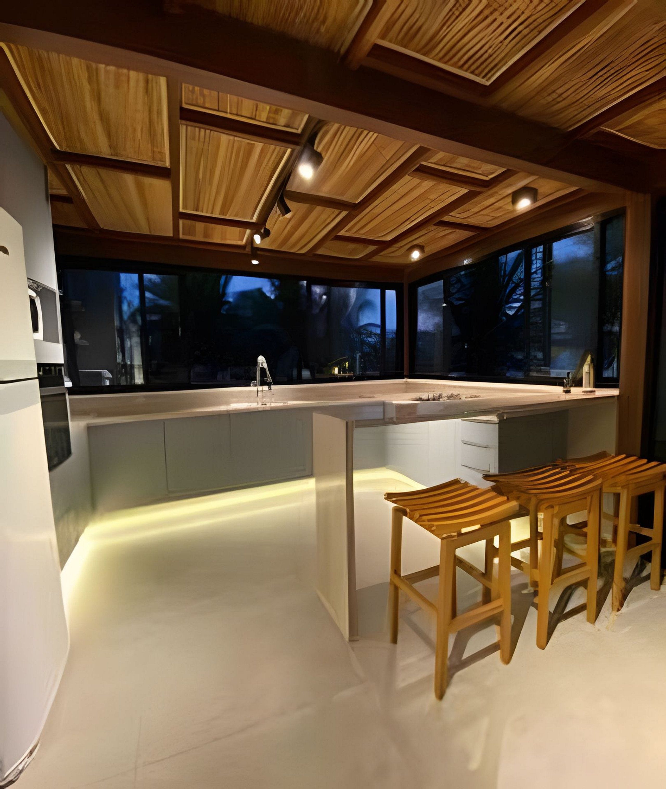 A modern kitchen with a central island, wooden bar stools, and large windows.