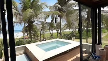 Ein moderner Poolbereich im Freien mit Blick auf den Strand und Palmen.