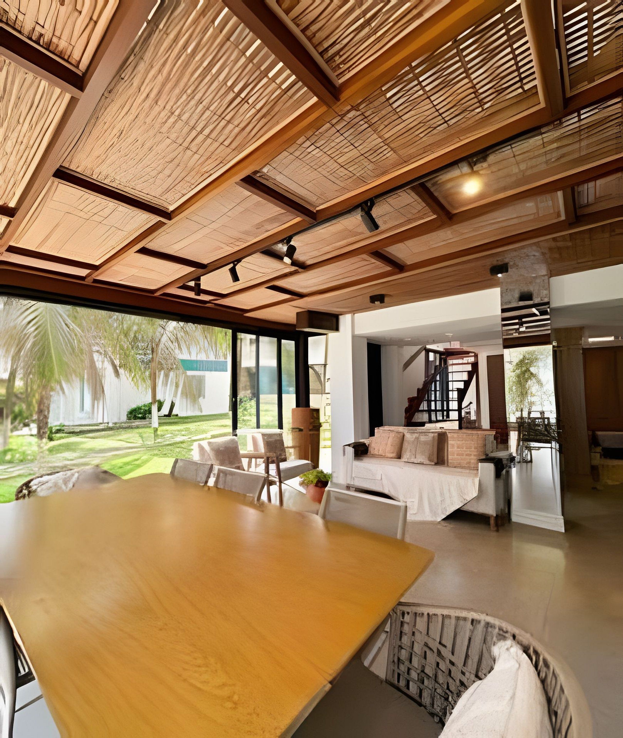 A spacious room with a large wooden table, comfortable seating, and a view of the outdoors.