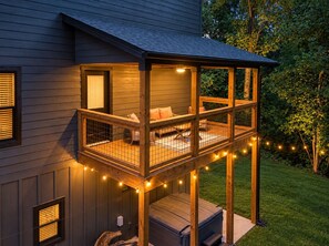 A two-story house with a covered deck and a hot tub. - Modern Mountain Chalet | Views, Hot Tub & Fire Pit (Gatlinburg)
