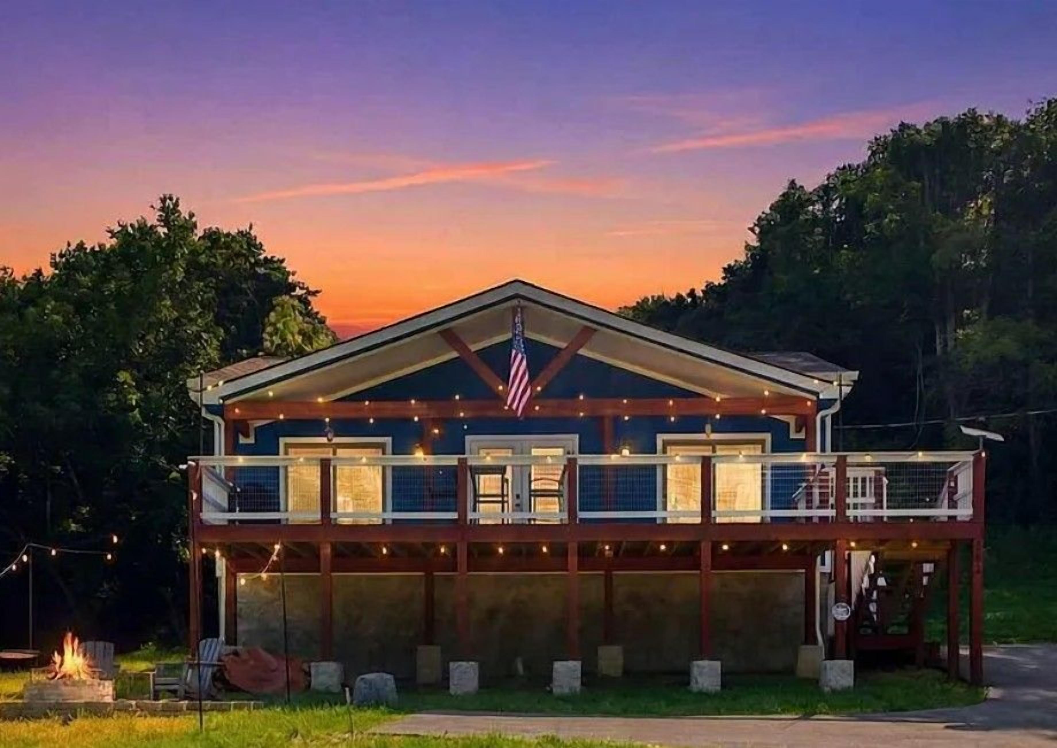 A two-story building with a balcony, a fire pit, and an American flag.