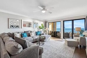 A spacious living room with a large sofa, a coffee table, and a view of the balcony. - SD 303: Sea La Vie 303 - Your Gulf-Front Escape (Fort Walton Beach)
