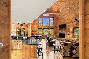 A spacious cabin interior with a kitchen, dining area, and living room. - Luxury Home|Steps from Whiteface|Near Lake Placid (Wilmington)