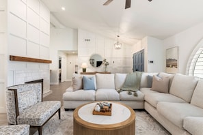 A spacious living room with a sectional sofa, a round coffee table, and a fireplace. - NEW Sonoran Sol Modern Pool Oasis Near Kierland (Scottsdale)