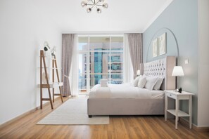A modern bedroom with a large bed, a bedside table, a lamp, and a view of the city through the window. - Luxury1BR in Downtown/Next Dubai Mall & Burj Khalifa (Dubai)