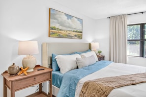 A bedroom with a bed, two bedside tables, a lamp, a remote control, a painting, and a window with curtains. - Near 17 Springs Spacious 3BR Millbrook Home (Millbrook)
