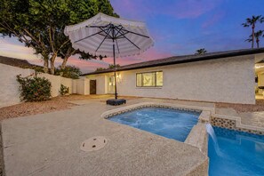 A residential swimming pool with a covered patio area, a small deck, and a house with a white exterior. - NEW The Fairmont Kierland Pool Spa Daybeds (Scottsdale)