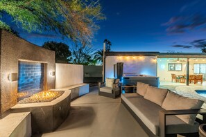 An outdoor patio with a fire feature, seating, and a pool area. - The Brexton Luxe Scottsdale Resort-style Oasis (Scottsdale)