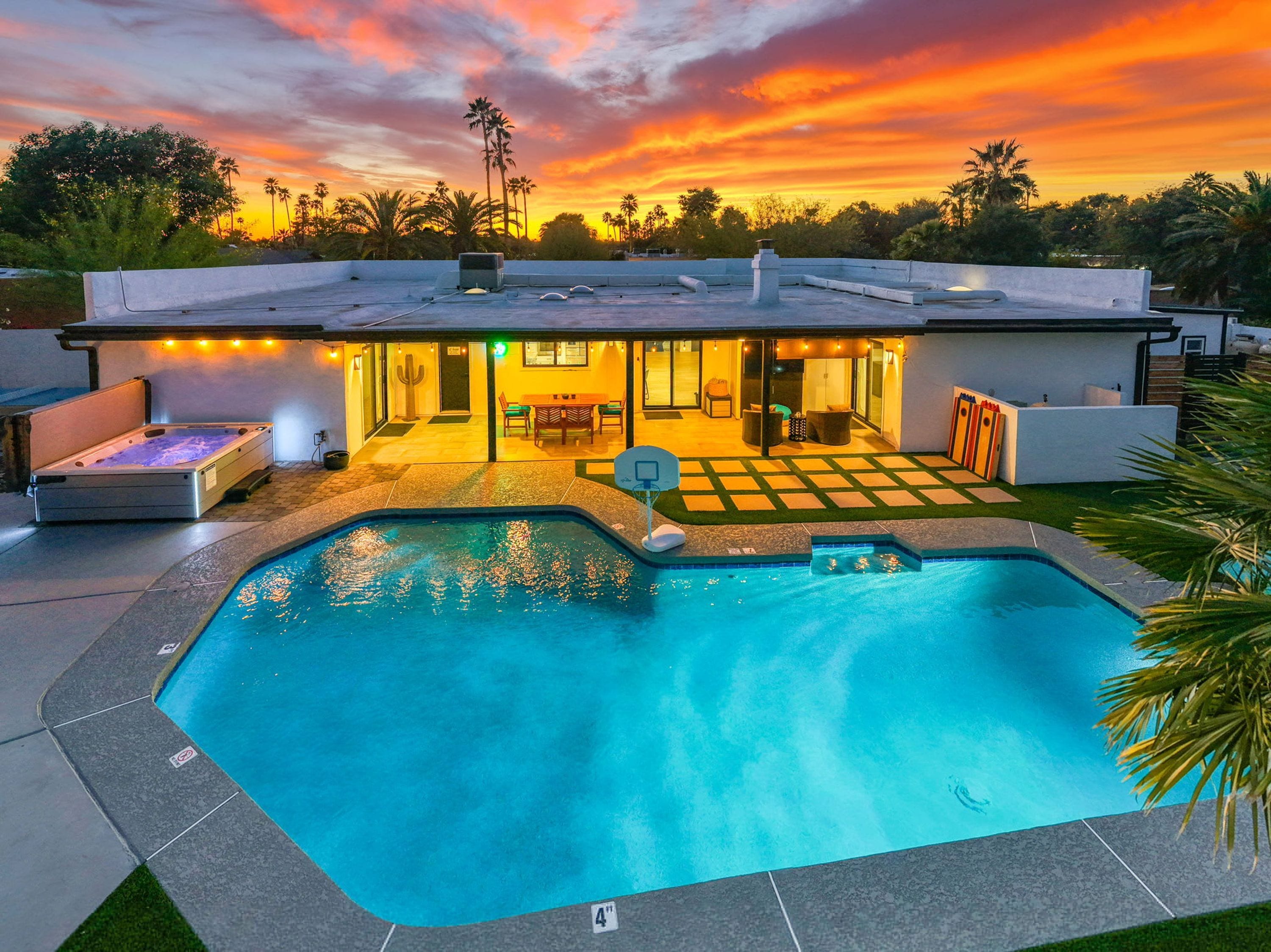 A modern house with a swimming pool, outdoor seating, and a patio area.