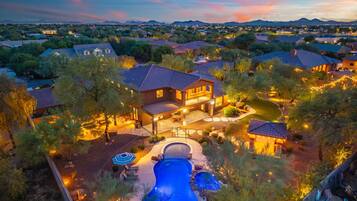 A residential area with multiple houses, a swimming pool, and a well-maintained lawn.