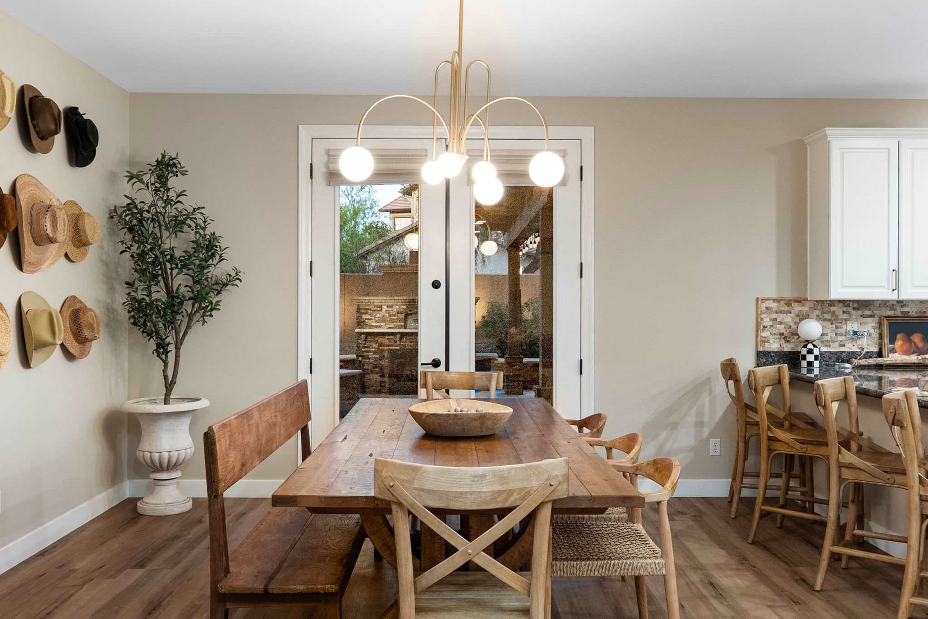 A dining area with a wooden table, chairs, and a hanging light fixture.