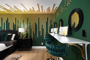Une chambre moderne avec un lit, une table de chevet, une lampe et un bureau avec des chaises.