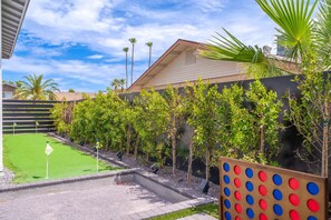 A residential property with a green lawn, a tennis court, and a wooden fence with a colorful dot pattern. - NEW Luna Lunera Gameroom Pool Sleeps 14 (Scottsdale)