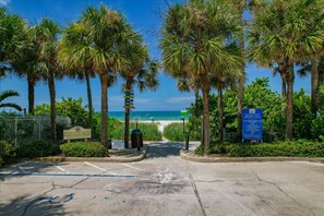 A paved entrance to a beach area with palm trees, a sign for Indian Rocks Beach, and a parking sign. - Beach Cottage Close to the Beach Pet Friendly (Indian Rocks Beach)