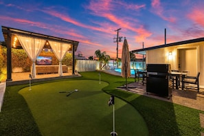 A backyard with artificial turf, a pool, a barbecue area, and a covered seating area. - NEW The Tipsy Cactus Old Town Oasis Pool Bar Putt (Scottsdale)