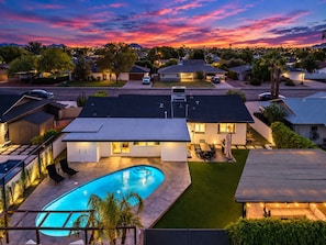 A residential area with a swimming pool, houses, and a sunset sky. - NEW The Tipsy Cactus Old Town Oasis Pool Bar Putt (Scottsdale)