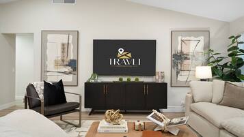 A modern living room with a black entertainment unit, a sofa, a coffee table, and two framed abstract paintings.