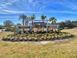 A signpost with 'MORGAN TOWN' written on it, surrounded by landscaped greenery and palm trees. - New Listing! In Morgantown Pools/Pickleball (Gulf Shores)