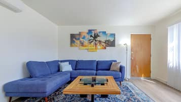 A living room with a blue sofa, a coffee table, and a patterned rug.