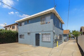 A two-story residential building with a flat roof, a satellite dish, and a gated entrance. - Quaint & Cozy Hideaway! 15 Min to LAX (Los Angeles)