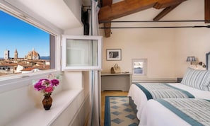 Une chambre d’hôtel avec un lit, une table de chevet et une fenêtre donnant sur un paysage urbain.