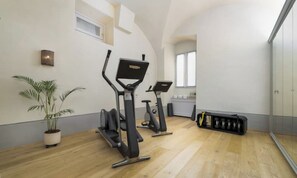 Een sportschool met trainingsapparatuur, een potplant en een opslagruimte.
